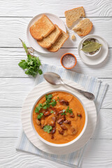 creamy carrot beef soup in a white bowl
