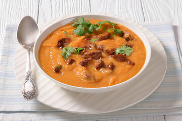 creamy carrot beef soup in a white bowl