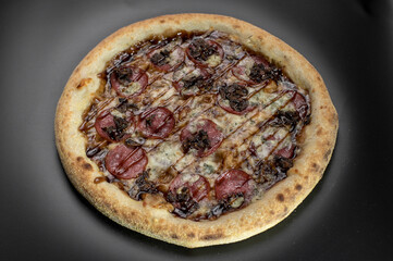 details of the pizza application; juicy pizza from the oven with mushrooms, tomatoes and bacon and sprinkled with parmesan cheese