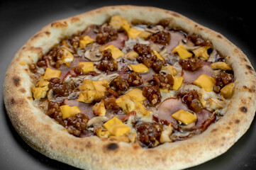 details of the pizza application; juicy pizza from the oven with mushrooms, tomatoes and bacon and sprinkled with parmesan cheese