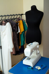 A sewing machine stands on a table with sentimental paper, chalk and pins, against the background...
