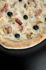 details of the pizza application; juicy pizza from the oven with mushrooms, tomatoes and bacon and sprinkled with parmesan cheese