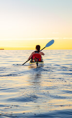 Solo Sunset Kayaking Adventure Over Calm Ocean Waters
