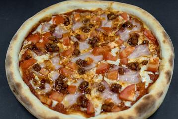 details of the pizza application; juicy pizza from the oven with mushrooms, tomatoes and bacon and sprinkled with parmesan cheese