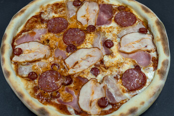 details of the pizza application; juicy pizza from the oven with mushrooms, tomatoes and bacon and sprinkled with parmesan cheese