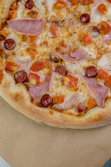 details of the pizza application; juicy pizza from the oven with mushrooms, tomatoes and bacon and sprinkled with parmesan cheese