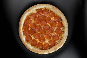 details of the pizza application; juicy pizza from the oven with mushrooms, tomatoes and bacon and sprinkled with parmesan cheese