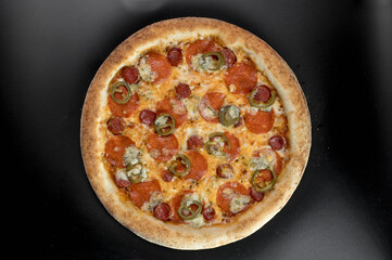 details of the pizza application; juicy pizza from the oven with mushrooms, tomatoes and bacon and sprinkled with parmesan cheese