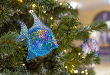 Blue glass fish with mother-of-pearl scales on a Christmas tree.