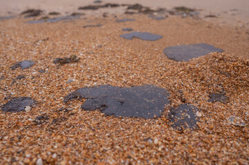 Fuel oil stains on the Black Sea coastline. Environmental disaster, environmental pollution. Oil spill