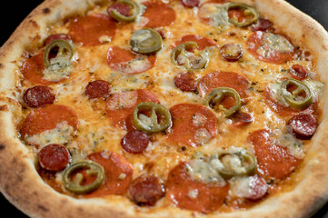 details of the pizza application; juicy pizza from the oven with mushrooms, tomatoes and bacon and sprinkled with parmesan cheese