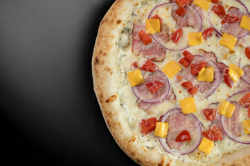 details of the pizza application; juicy pizza from the oven with mushrooms, tomatoes and bacon and sprinkled with parmesan cheese