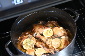 Close-Up of Roasted Chicken Leg with Lemon in Black Pot – Rustic Home Cooking Background