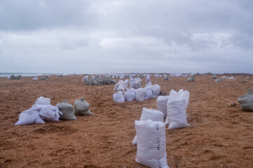 A pile of bags of collected fuel oil on the coastline after an environmental disaster on the Black...