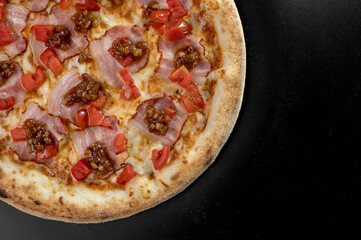details of the pizza application; juicy pizza from the oven with mushrooms, tomatoes and bacon and sprinkled with parmesan cheese