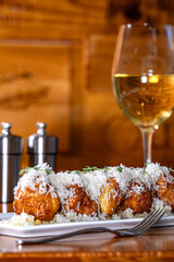 Parmesan Beignets drizzled with honey and diced pears and topped with fresh parmesan