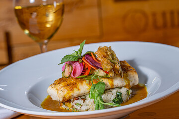 Pan Seared Cobia over risotto and topped with raw vegetables