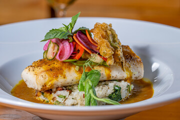 Pan Seared Cobia over risotto and topped with raw vegetables