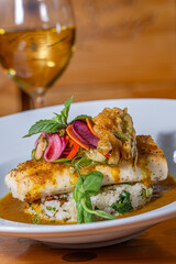Pan Seared Cobia over risotto and topped with raw vegetables