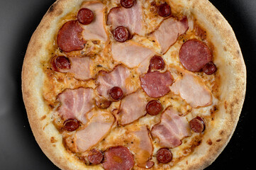 details of the pizza application; juicy pizza from the oven with mushrooms, tomatoes and bacon and sprinkled with parmesan cheese