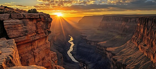 A dramatic canyon landscape with towering rock formations, a river winding through the valley below, and the warm light of the setting sun casting long shadows