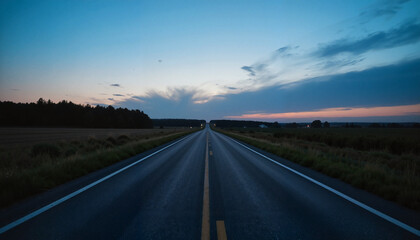 Naklejka premium Empty highway stretching into dusk with colorful sky and distant headlights approaching