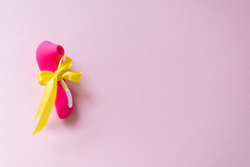 pink vibrating sex toys with yellow bow on a pink background