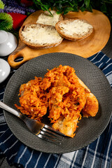 Fish in Greek kind with vegetables and tomato sauce.
