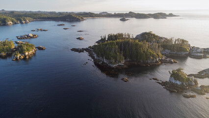 Hazy sunset over a small archipelago of smaller islands sitting the the calm waters of West Coast British Columbia