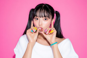 ピンク背景で撮影をしたスポーティな服装をした若い女性のキュートなポートレート 
