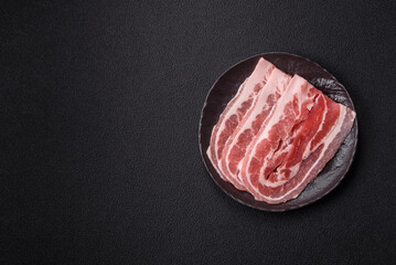 Fresh raw bacon sliced with spices and herbs