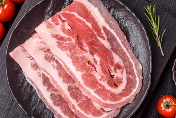 Fresh raw bacon sliced with spices and herbs