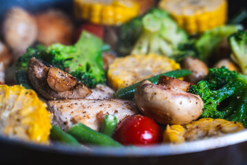 Background with vegetable texture. Corn, broccoli, mushrooms and green beans are fried in a pan. Close-up. The concept of healthy eating.