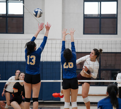 Volleyball player hitting the ball over the block