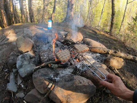 Toasting bread for breakfast on a campfire in the early morning, at camping Chutes Frase, Canada