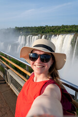 Turista feliz tomándose una selfie en el Parque Nacional Iguazú, con la Garganta del Diablo de...