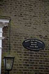 Facade of a British building in Oxford with climbing plant without leaves