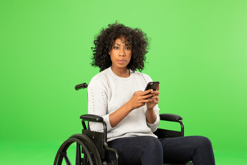 Fototapeta premium Disabled black woman holding smartphone, looking at camera