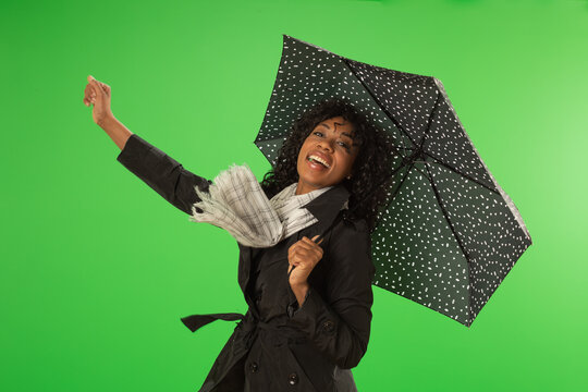 Pretty African American woman has fun on rainy day on greenscreen