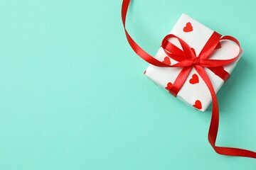 Gift box with red hearts on color  background