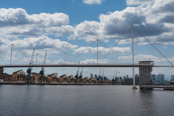 The image captures the Emirates Air Line cable cars over Royal Victoria Dock in London, with...