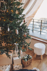 Bright festive design: Christmas tree and decor. The concept of celebrating New Year and Christmas. Gifts in craft packaging under the Christmas tree. basket with christmas balls