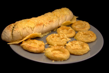 Kräuterbaguette und Tintenfischringe mit Käse überbacken