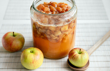 Making your own apple cider vinegar at home, fermenting chopped apples in glass jar, jar covered with dark linen towel. Work in progress.
