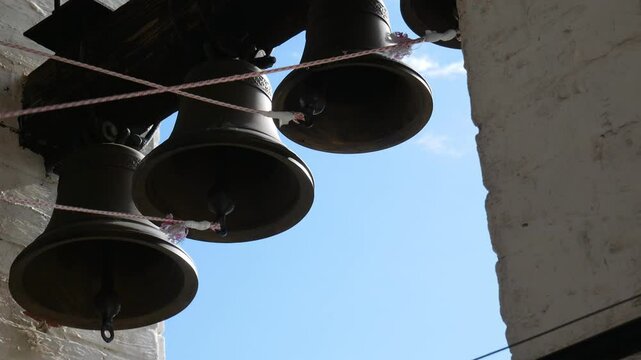 Bell ringer rings the bells of the Orthodox church. Ringing of bells in Christian church. View of the bells from below