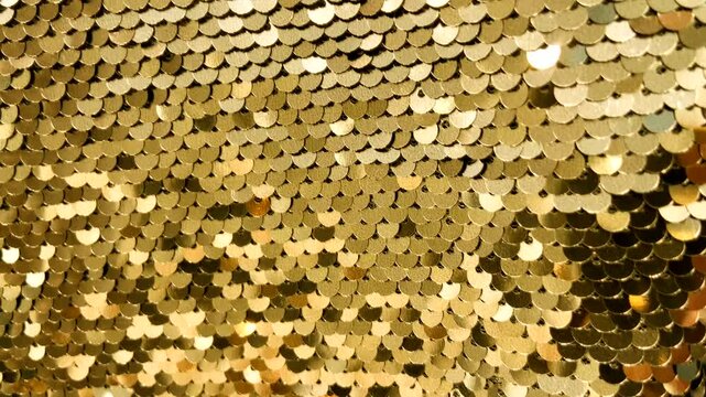 Golden sequin fabric with shimmering highlights luxurious textured background for design.Holiday abstract glitter texture with blinking lights,4K video