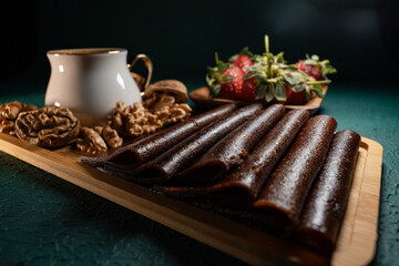 Delicious dessert in a wooden plate with walnuts, strawberries and traditional Turkish coffee on top