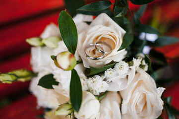 Romantic Wedding Bouquet with Silver Rings nestled Among Cream Roses