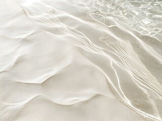 Obraz premium A serene sandy beach scene where gentle waves meet the shore in clear, shallow water