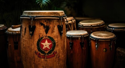 Fototapeta premium Group of various drums, including conga with star emblem, set against dark background